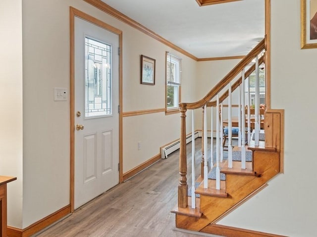 entryway with crown molding, light wood finished floors, stairs, and a wealth of natural light