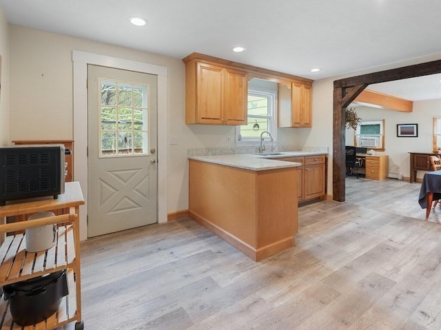 kitchen featuring light wood-style floors, a sink, recessed lighting, and light countertops