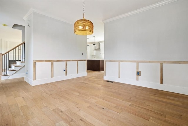 108 S St, Reading, MA 01867 - spare room featuring light wood-style flooring, ornamental molding, and stairs