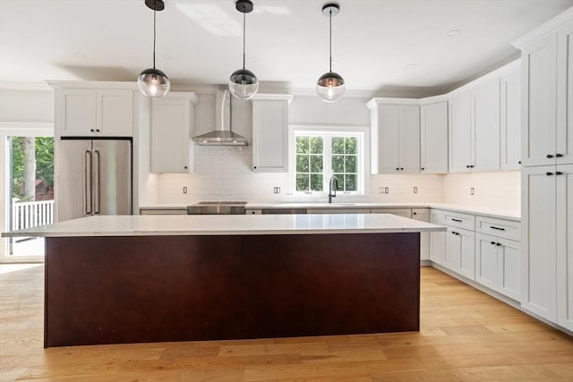 108 S St, Reading, MA 01867 - kitchen with wall chimney exhaust hood, high quality fridge, a center island, and light countertops