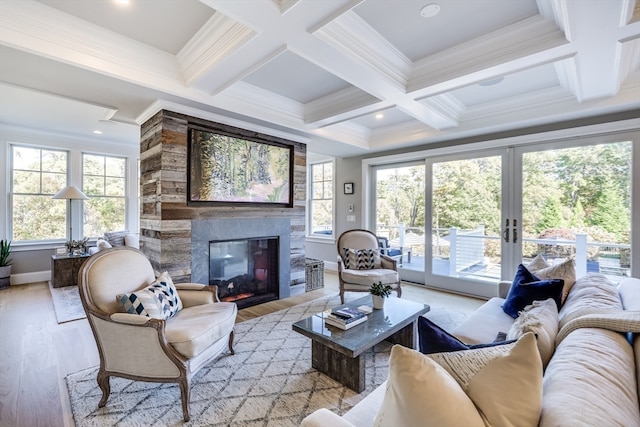 living room with french doors, coffered ceiling, a stone fireplace, beamed ceiling, and light hardwood / wood-style flooring