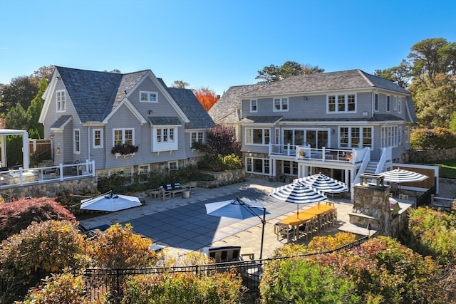 rear view of house featuring a patio, a sunroom, and a wooden deck