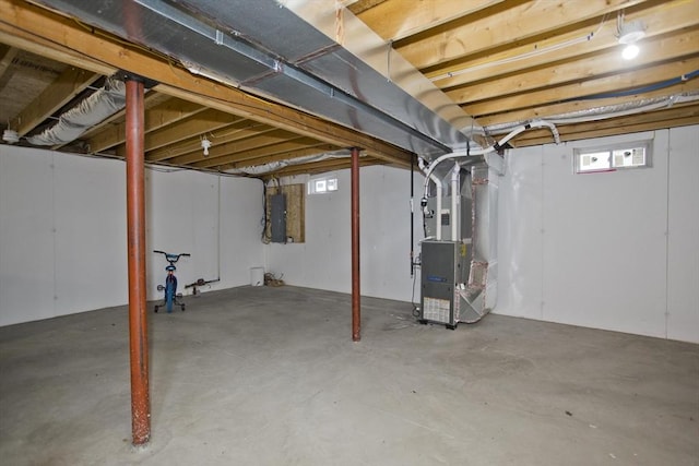 basement featuring heating unit and electric panel