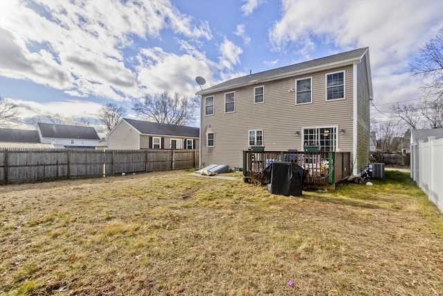 back of property with a yard and central AC