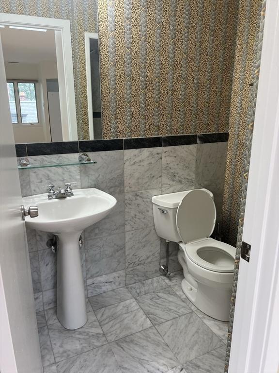 121 Longwood Ave Unit 4B, Brookline, MA 02446 - half bath featuring marble finish flooring and tile walls
