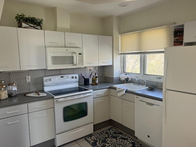 121 Longwood Ave Unit 4B, Brookline, MA 02446 - kitchen with white appliances, backsplash, dark countertops, and white cabinetry