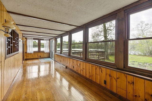 38 Lakeshore Dr, Wayland, MA 01778 - unfurnished sunroom with wooden walls, hardwood / wood-style flooring, a textured ceiling, a water view, and beamed ceiling