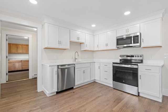 59 Altamont St, Haverhill, MA 01830 - kitchen with appliances with stainless steel finishes, a sink, light countertops, white cabinets, and crown molding