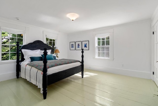 bedroom with ornamental molding and wood finished floors