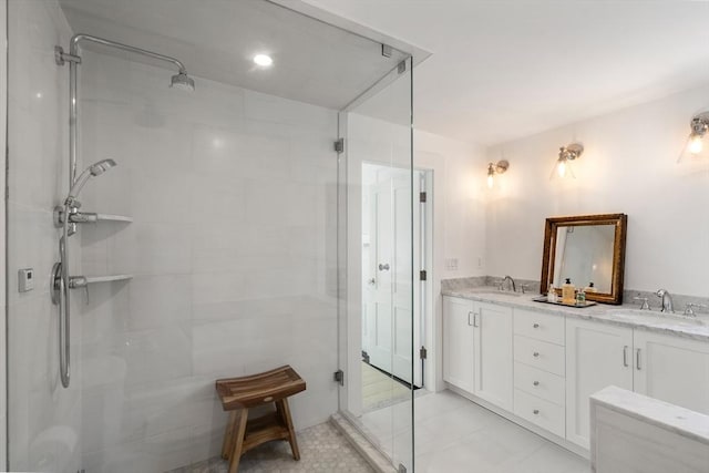 bathroom with double vanity, tiled shower, and a sink