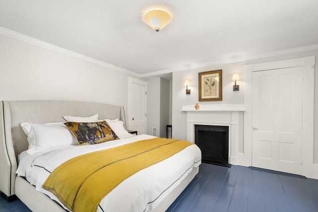 bedroom with a fireplace with flush hearth, ornamental molding, and dark wood-style flooring