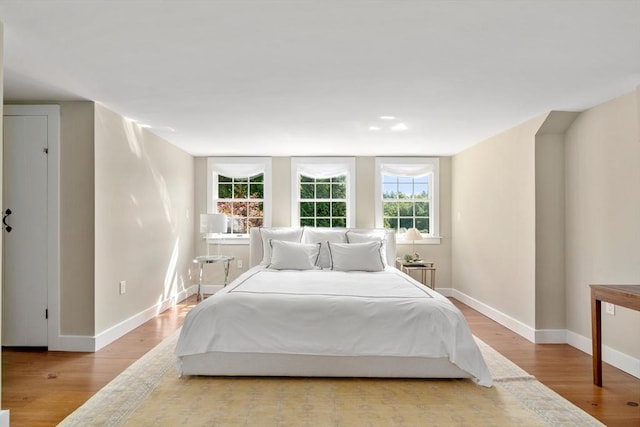 bedroom with light wood-style floors and baseboards