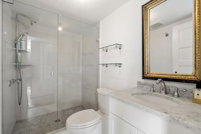 bathroom featuring toilet, a shower stall, and vanity