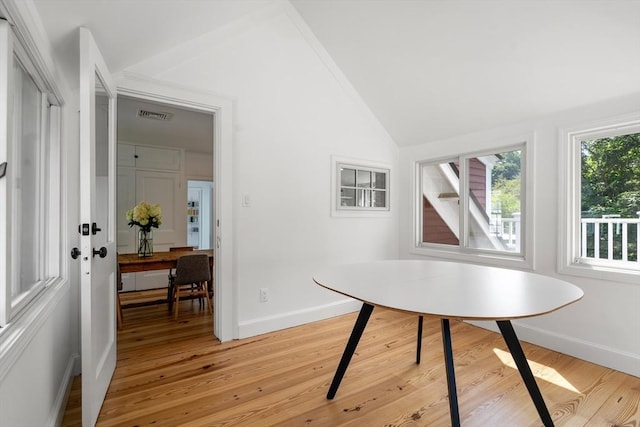 dining area with vaulted ceiling, light wood finished floors, visible vents, and baseboards