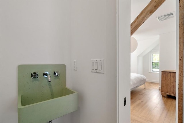 bathroom with visible vents, a sink, and wood finished floors