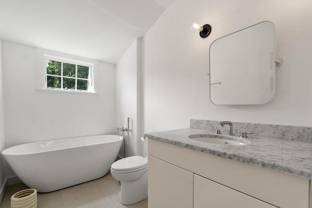 full bathroom with lofted ceiling, a freestanding bath, vanity, and toilet