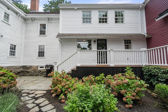 rear view of property featuring a patio area and a chimney