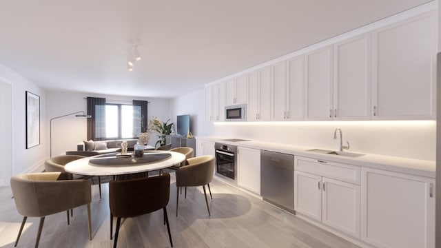 kitchen featuring light hardwood / wood-style floors, stainless steel appliances, sink, and white cabinetry