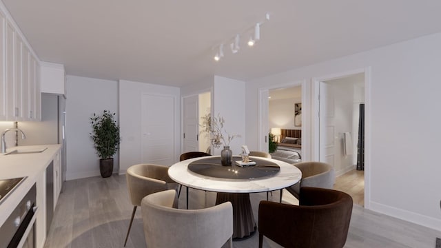 dining room with light wood-type flooring and sink