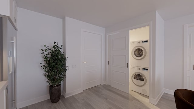 laundry room featuring stacked washer / dryer and light wood-type flooring