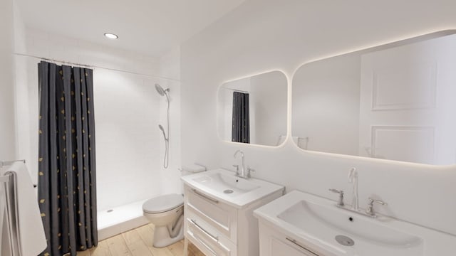 bathroom featuring hardwood / wood-style flooring, toilet, vanity, and a shower with curtain