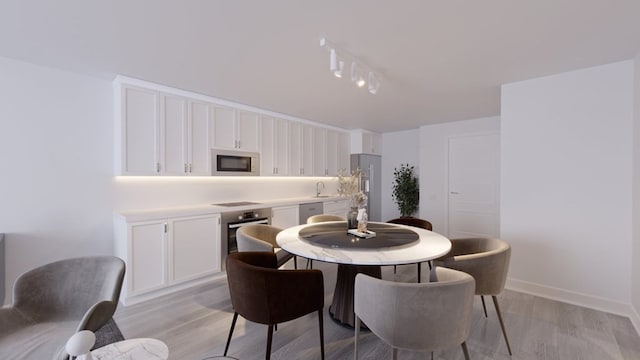 dining area with sink and light hardwood / wood-style floors