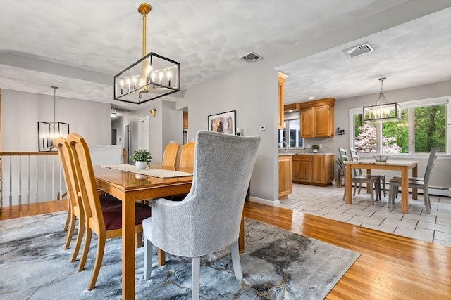 2 Cider Mill Rd, Peabody, MA 01960 - dining area featuring a chandelier, light wood-style floors, and baseboards