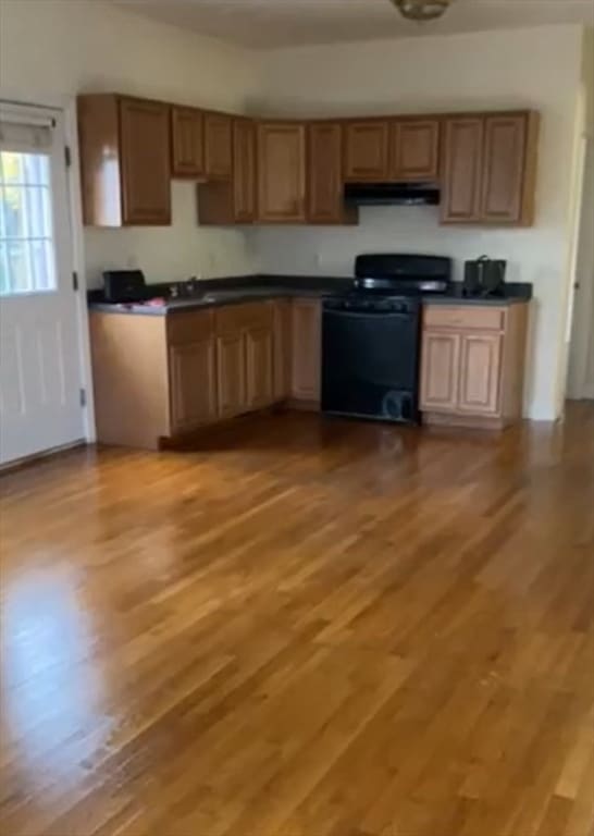 kitchen with black range oven and light hardwood / wood-style floors