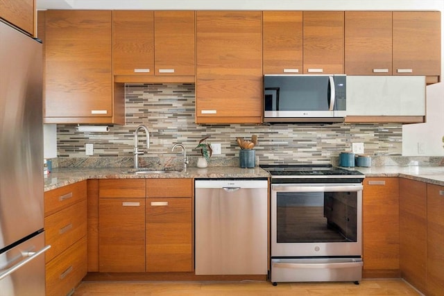 23 Hall Ave Unit 1, Somerville, MA 02144 - kitchen featuring appliances with stainless steel finishes, a sink, light stone countertops, and tasteful backsplash
