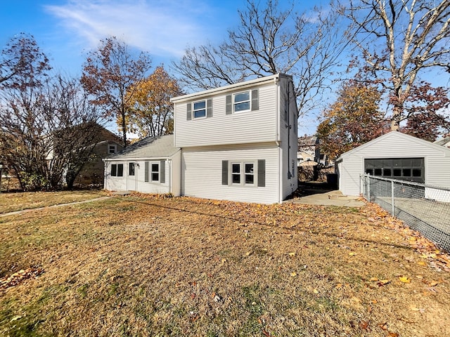 view of front of home with a garage, an outdoor structure, and a front yard