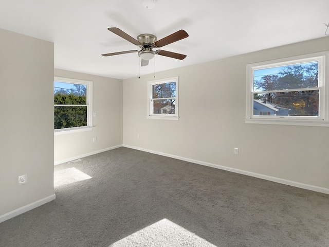 unfurnished room featuring dark colored carpet and ceiling fan