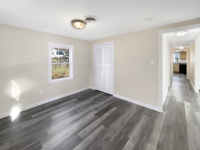 unfurnished bedroom featuring dark wood-type flooring and a closet