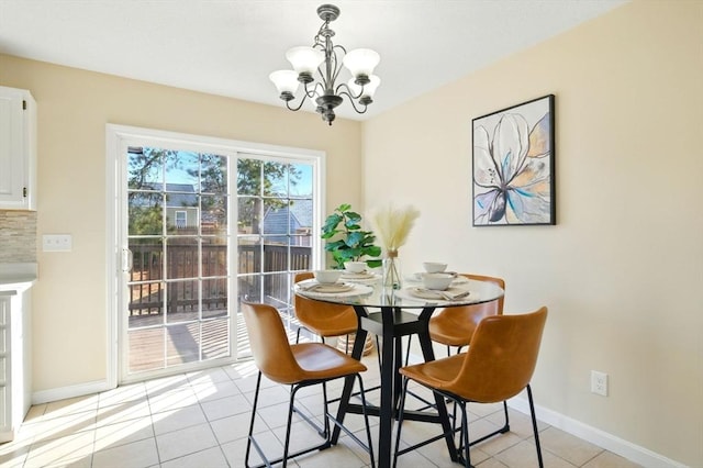 dining room with baseboards, a notable chandelier, and light tile patterned flooring