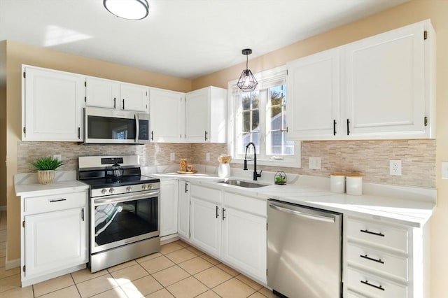 kitchen featuring decorative backsplash, appliances with stainless steel finishes, light countertops, white cabinetry, and a sink