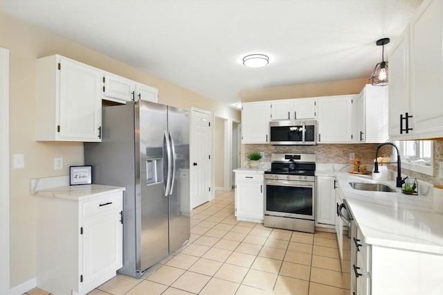 kitchen featuring stainless steel appliances, a sink, light countertops, and white cabinetry