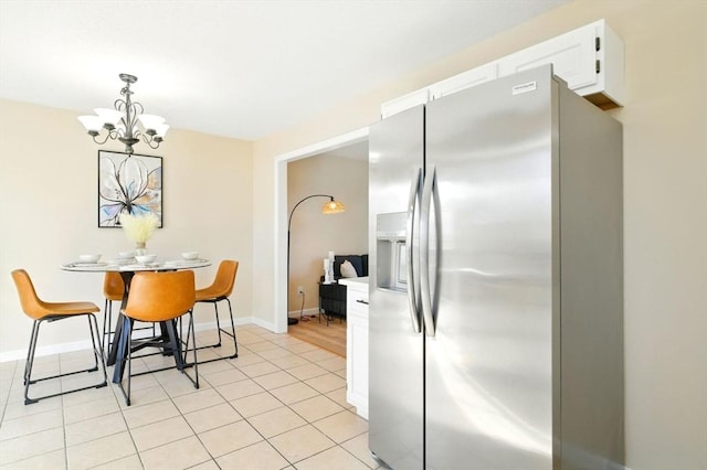 dining area with an inviting chandelier, baseboards, and light tile patterned flooring