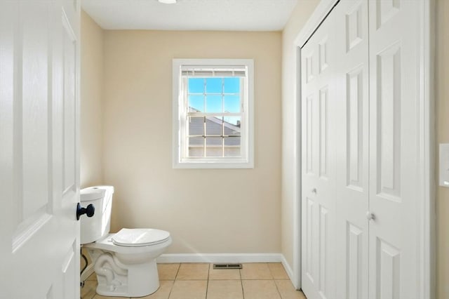 bathroom featuring tile patterned flooring, baseboards, visible vents, and toilet