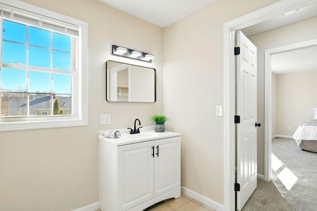 ensuite bathroom featuring connected bathroom, vanity, and baseboards