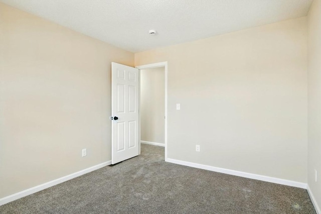 unfurnished room with carpet and baseboards