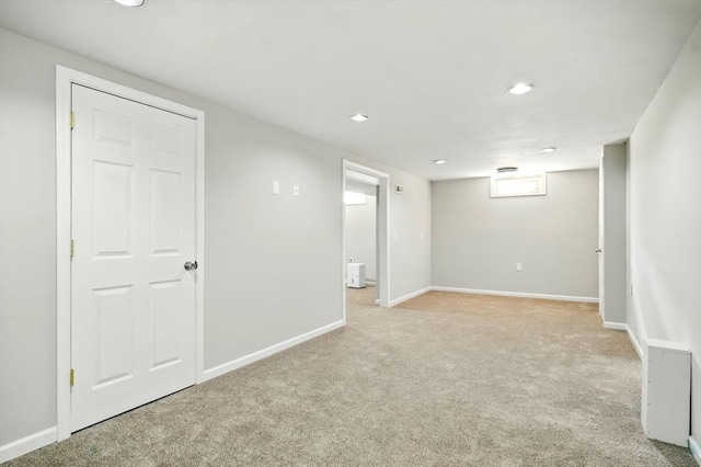 below grade area featuring recessed lighting, baseboards, and light colored carpet