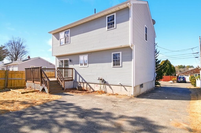 rear view of property featuring fence and a wooden deck