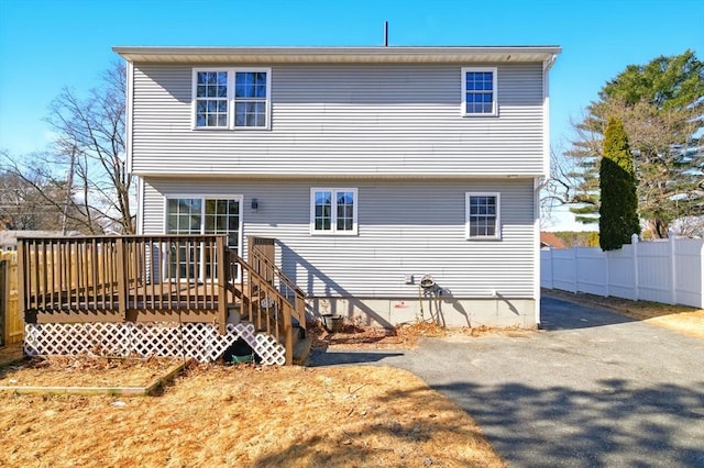 rear view of property featuring fence and a deck