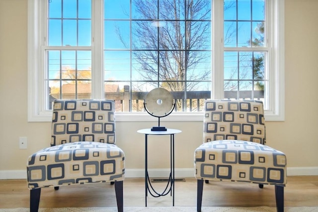 sitting room featuring visible vents, baseboards, and wood finished floors