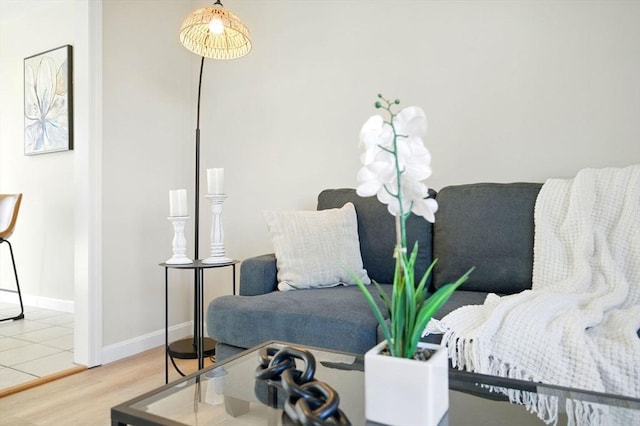 living area with baseboards and wood finished floors