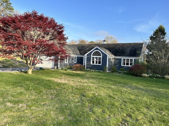 single story home featuring an attached garage, a front lawn, and a chimney