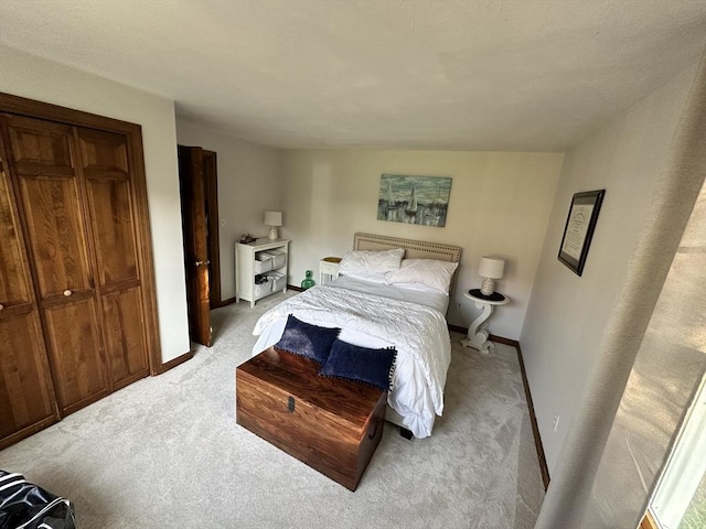 bedroom with baseboards and light carpet
