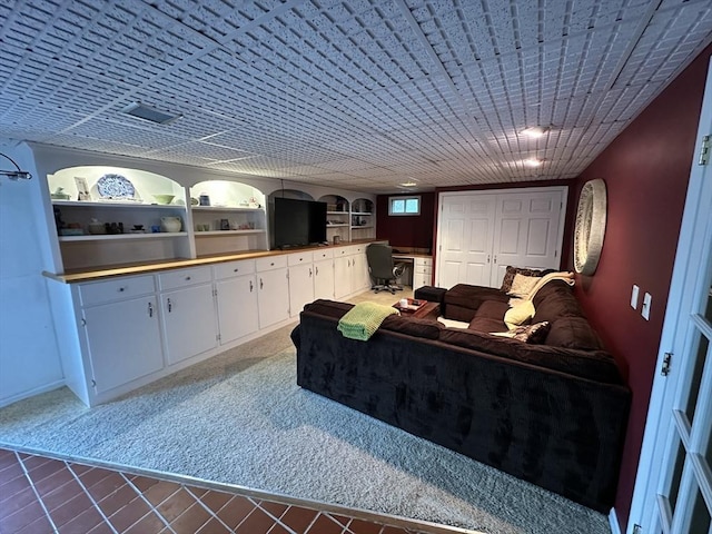 interior space featuring baseboards, tile patterned floors, and built in shelves