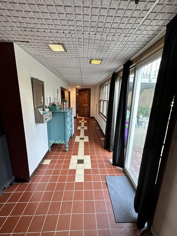 interior space with dark tile patterned floors and baseboards