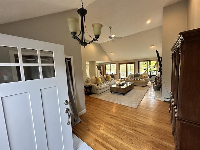 living area with recessed lighting, a baseboard heating unit, ceiling fan with notable chandelier, and light wood-style floors