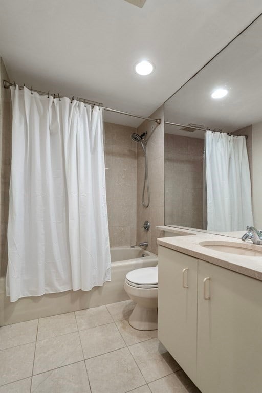 full bathroom featuring vanity, tile flooring, toilet, and shower / bathtub combination with curtain